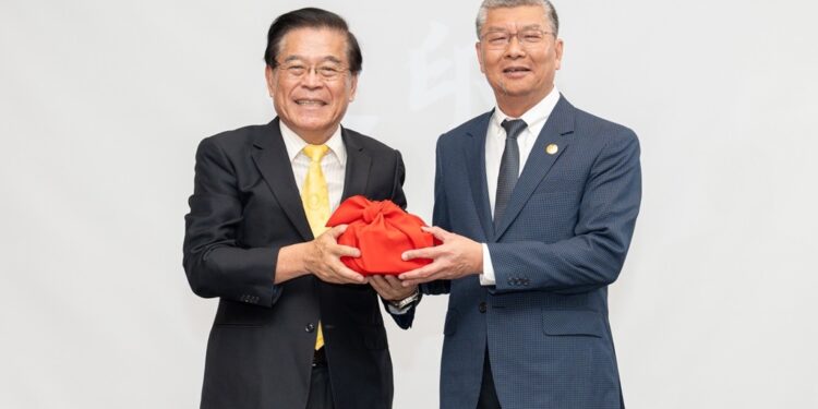 义守大学校长古源光(左)亲自为校友总会总会长张世昌(右)授印，象征传承与新章启动